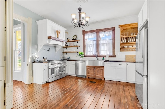 kitchen featuring white cabinets, appliances with stainless steel finishes, sink, and hardwood / wood-style floors