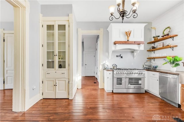 kitchen featuring stainless steel appliances, pendant lighting, an inviting chandelier, dark hardwood / wood-style floors, and white cabinetry