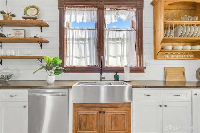 kitchen featuring butcher block counters, dishwasher, white cabinets, and sink