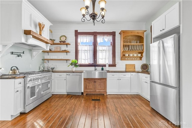 kitchen featuring white cabinets, appliances with stainless steel finishes, and light hardwood / wood-style flooring