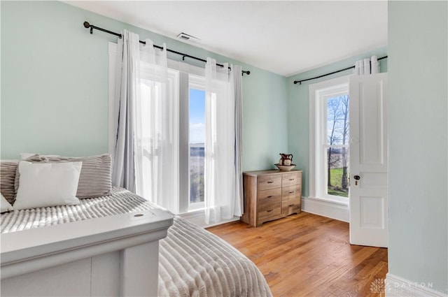 bedroom featuring light hardwood / wood-style flooring and multiple windows