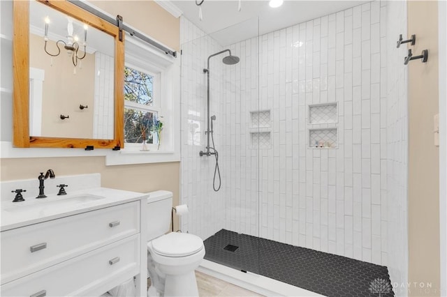 bathroom featuring vanity, toilet, and tiled shower