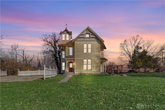 back house at dusk with a lawn