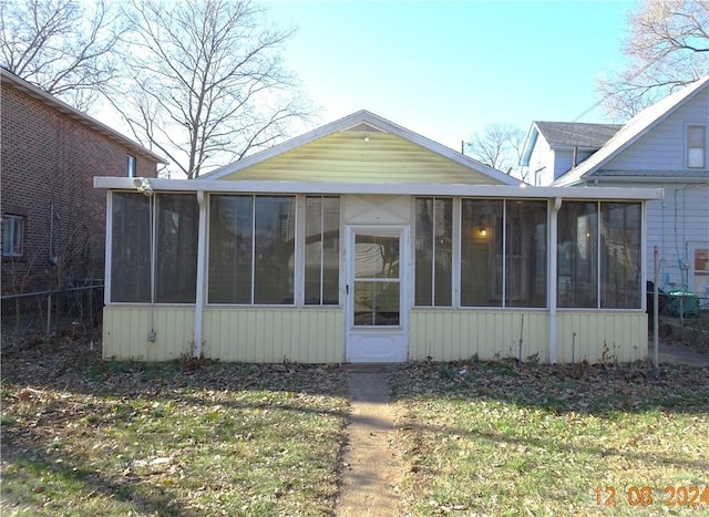 exterior space with a lawn and a sunroom