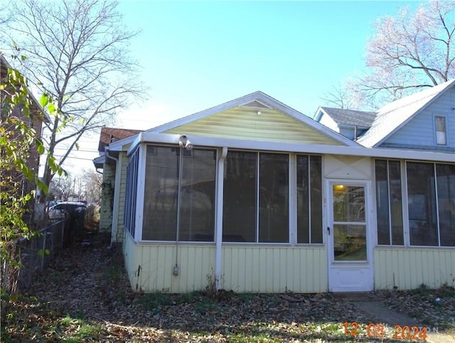 view of property exterior with a sunroom