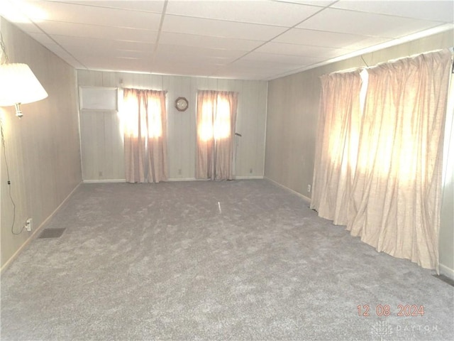 carpeted empty room with a drop ceiling