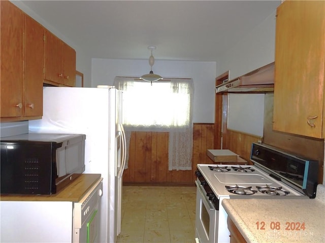 kitchen with wood walls and white gas range