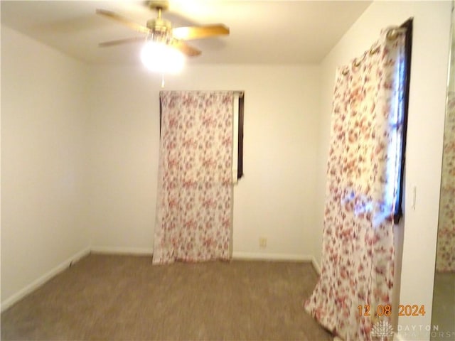 carpeted spare room featuring ceiling fan