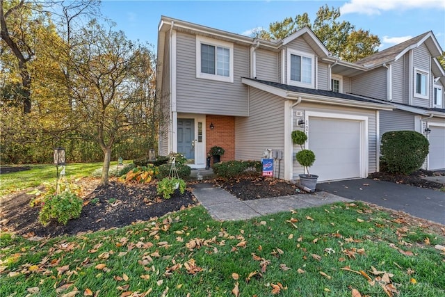 view of property with brick siding, driveway, and a garage