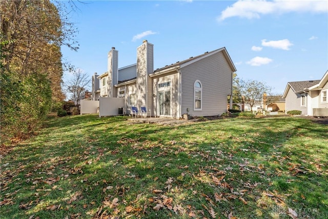 back of house with a yard and central AC unit