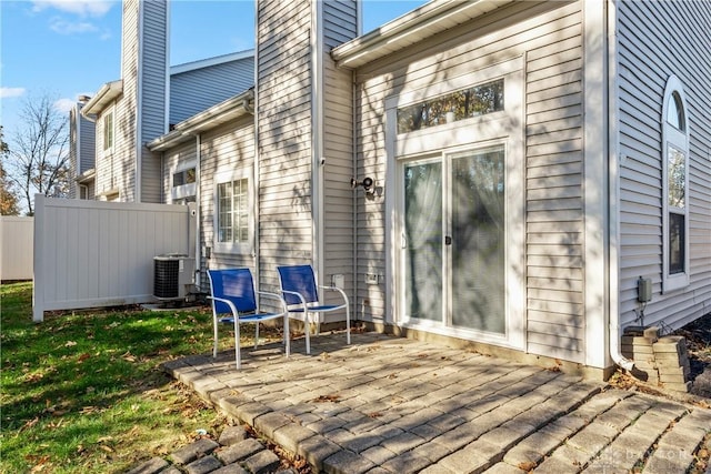 exterior space with a patio, cooling unit, a chimney, and fence