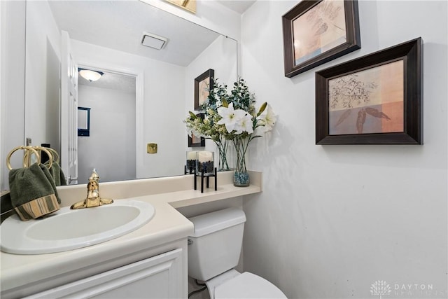 half bathroom with vanity and toilet