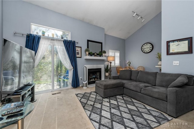 living room with carpet flooring, rail lighting, and vaulted ceiling