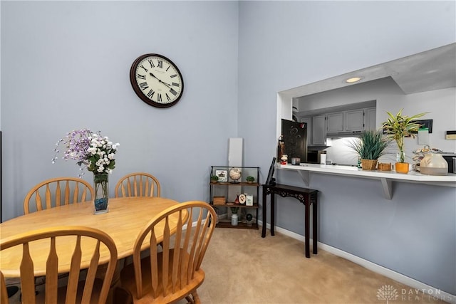 dining room with baseboards and light carpet