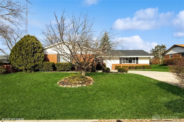 single story home with a garage, a front yard, brick siding, and driveway