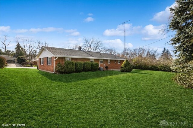 view of side of property with a yard and central air condition unit