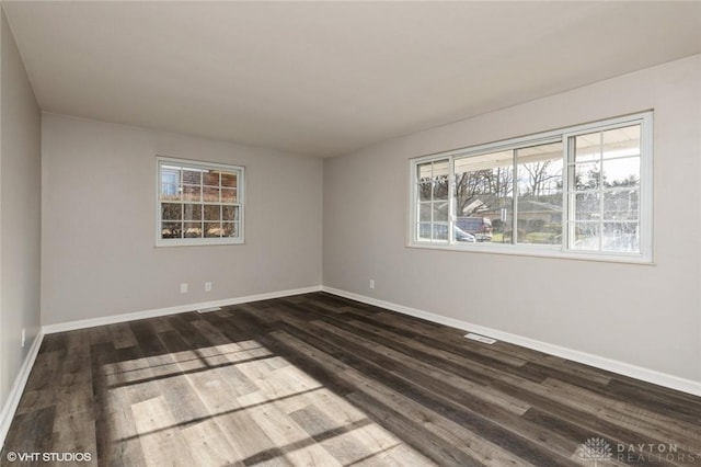 unfurnished room featuring dark wood-style floors and baseboards