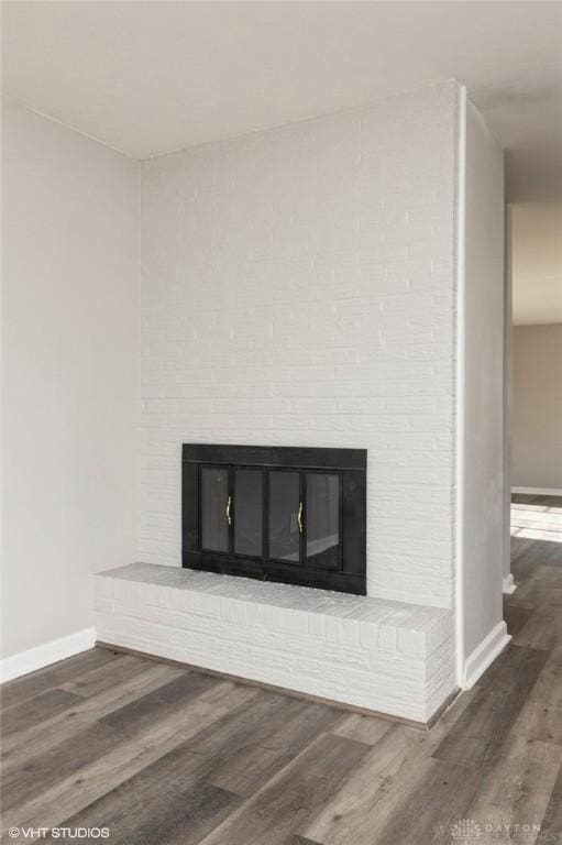 room details with a fireplace, baseboards, and wood finished floors