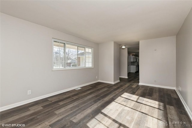 unfurnished room with dark wood-style floors and baseboards