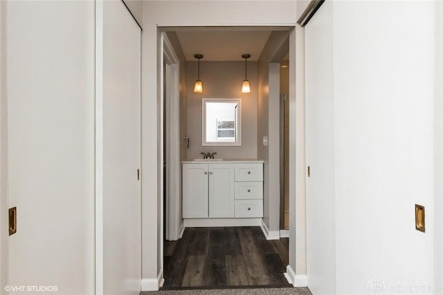 corridor featuring dark wood-style floors and baseboards