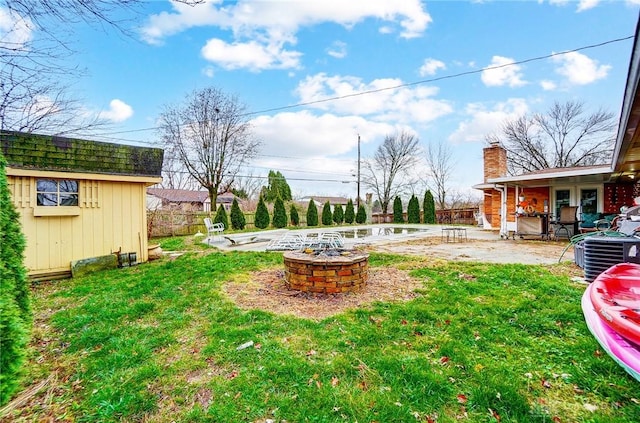 view of yard with a patio, central AC unit, and an outdoor fire pit