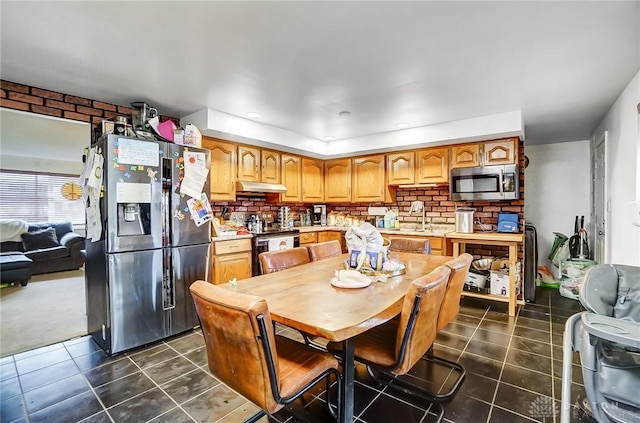 kitchen with sink, dark tile patterned floors, and stainless steel appliances