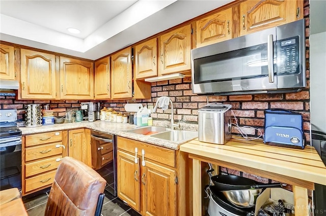 kitchen featuring dishwasher, dark tile patterned flooring, sink, range with electric stovetop, and butcher block counters