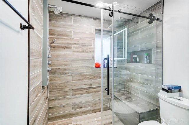 bathroom with toilet and an enclosed shower