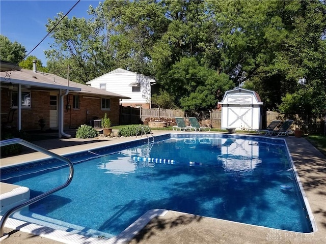 view of swimming pool with central AC, a patio, and a shed