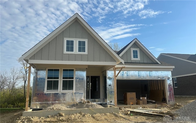 unfinished property with board and batten siding and a garage