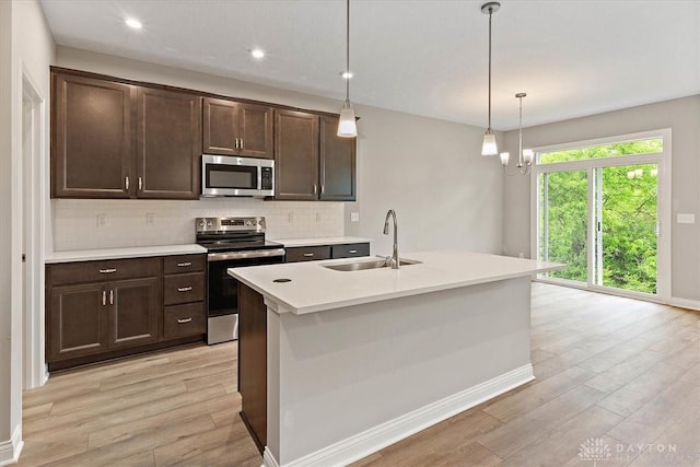 4517 Renaissance Blvd Unit 263, Franklin, OH 45005 - kitchen with appliances with stainless steel finishes, a sink, light wood finished floors, tasteful backsplash, and dark brown cabinetry