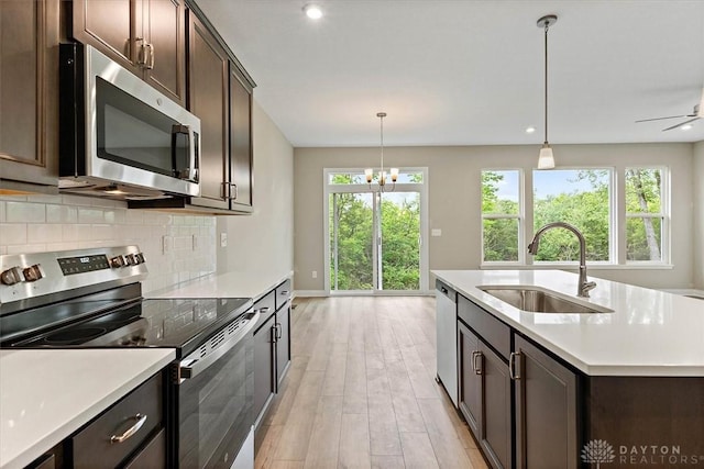 4517 Renaissance Blvd Unit 263, Franklin, OH 45005 - kitchen featuring stainless steel appliances, a sink, light wood-type flooring, dark brown cabinets, and tasteful backsplash