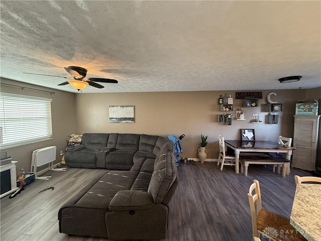 living room with hardwood / wood-style flooring, ceiling fan, and a textured ceiling