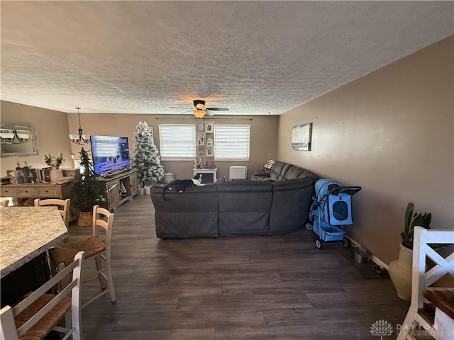 living room with dark hardwood / wood-style floors, ceiling fan, and a textured ceiling