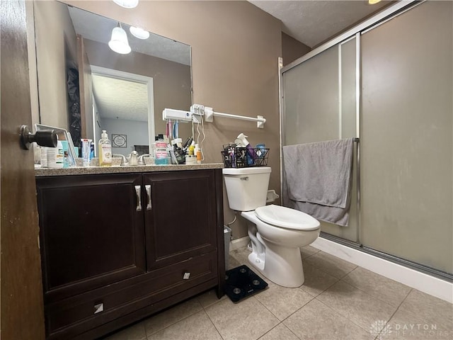 bathroom featuring tile patterned flooring, vanity, toilet, and a shower with shower door