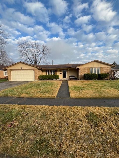 single story home featuring a front lawn and a garage