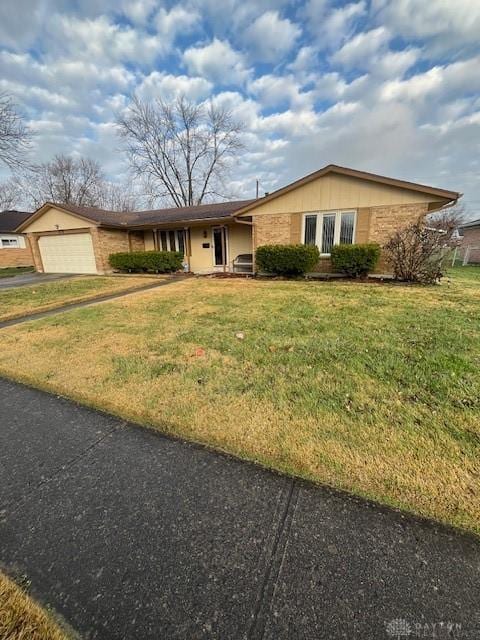 ranch-style house featuring a front lawn and a garage