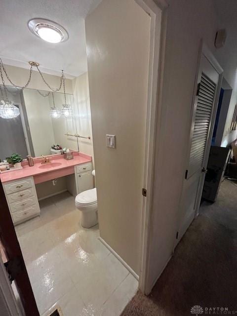 bathroom featuring a chandelier, tile patterned floors, vanity, and toilet