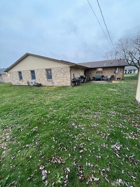 back of property featuring a yard and a patio