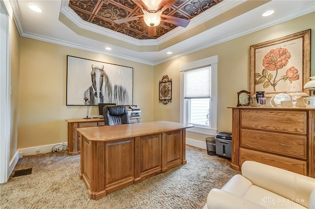 carpeted home office featuring a raised ceiling and ornamental molding