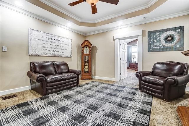 sitting room featuring carpet flooring, a raised ceiling, and ornamental molding