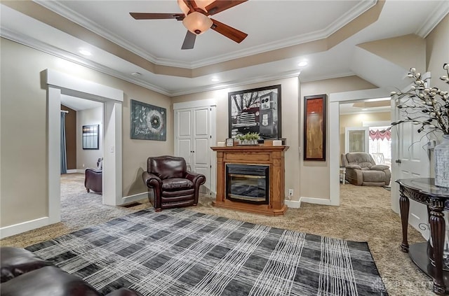 sitting room with carpet floors, a tray ceiling, ceiling fan, and crown molding