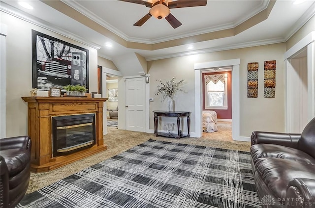 living area with carpet floors, ceiling fan, and ornamental molding