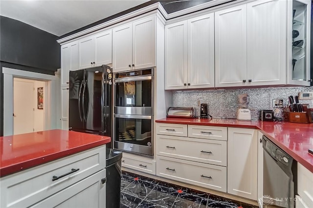 kitchen with white cabinetry, stainless steel appliances, and tasteful backsplash