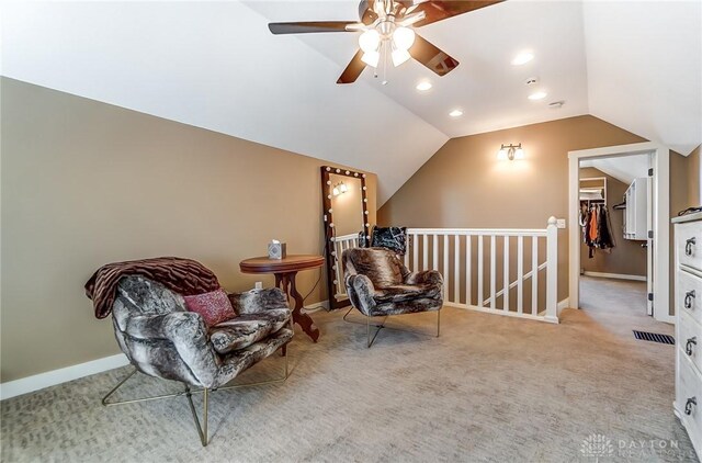 sitting room featuring ceiling fan, light colored carpet, and vaulted ceiling