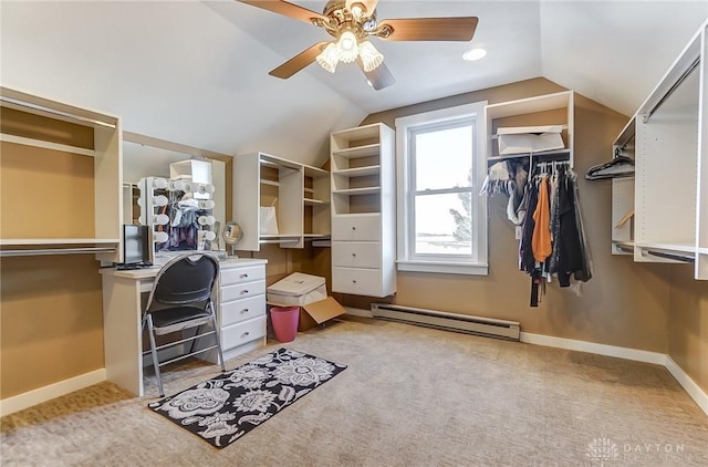 walk in closet with ceiling fan, a baseboard heating unit, light carpet, and vaulted ceiling