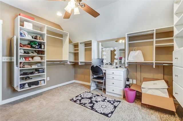 spacious closet with ceiling fan, light colored carpet, and vaulted ceiling