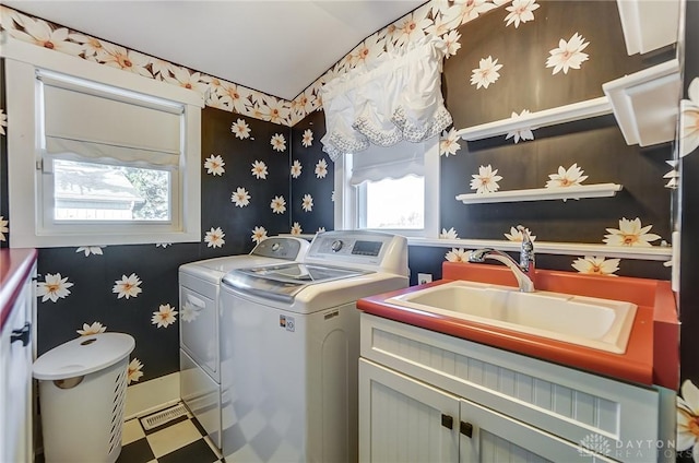 washroom with cabinets, sink, and washer and dryer