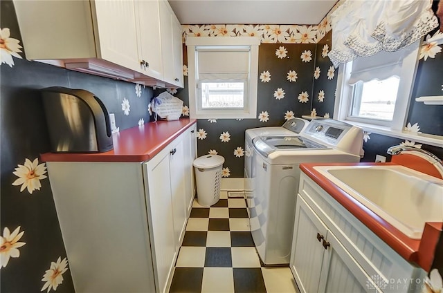 laundry room featuring washer and clothes dryer, a healthy amount of sunlight, cabinets, and sink