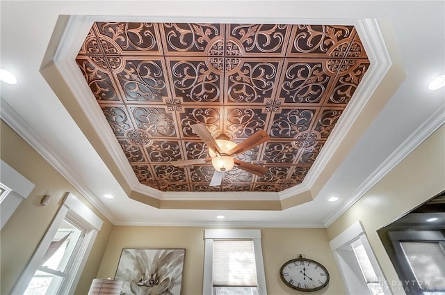 details featuring ceiling fan, crown molding, and a tray ceiling